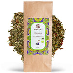 Bio Kräutertee Shavasana im 100 g Kraftpapierbeutel, Premium-Schlafgut-Mischung mit Baldrian und Melisse, laborgeprüfte Qualität, ohne Füllstoffe, lose Kräuter im Hintergrund.